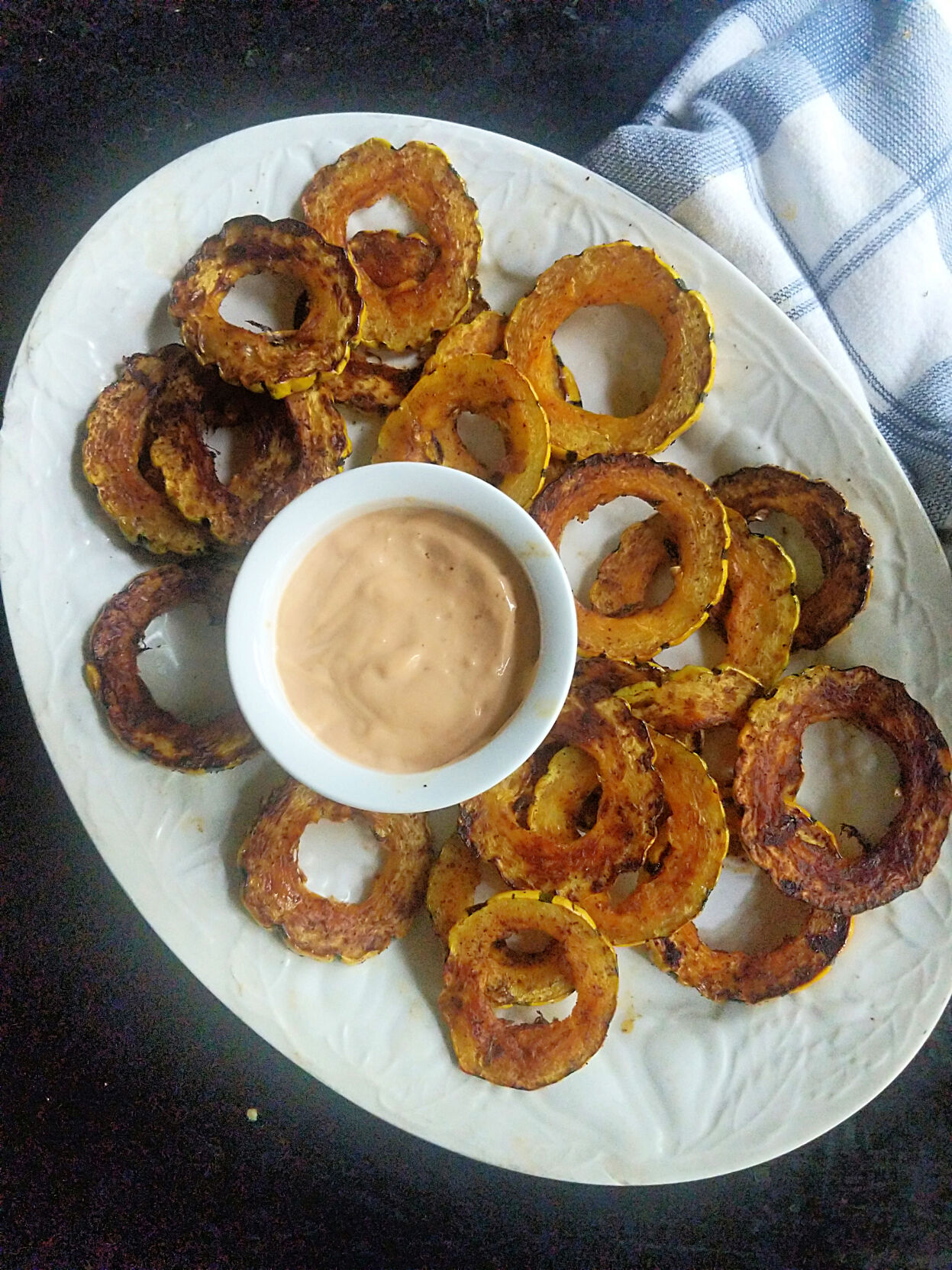 Rounds of roasted delicata squash are dusted in warm spices and served with a spicy chipotle mayo.